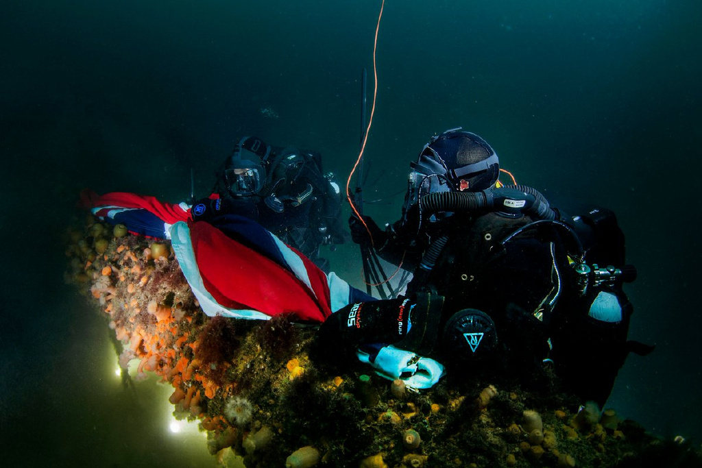 皇家海军潜水队将一面皇家海军军旗放置在皇家橡树号上残骸上。